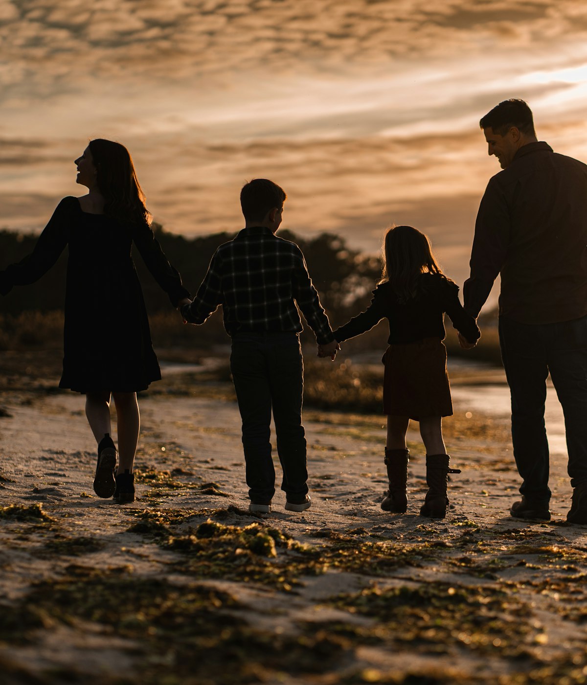 Family walking together on a beach at sunset