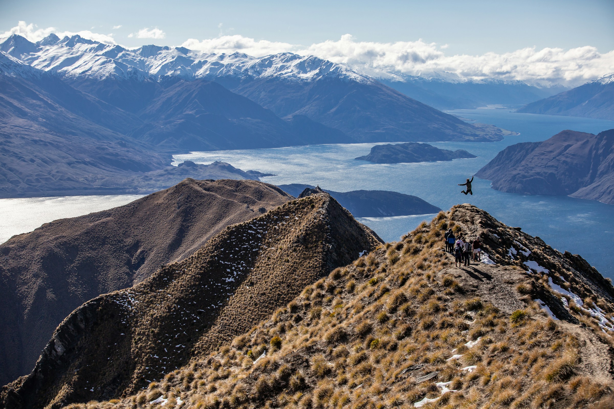 Solo traveller on a mountain ridge above a lake
