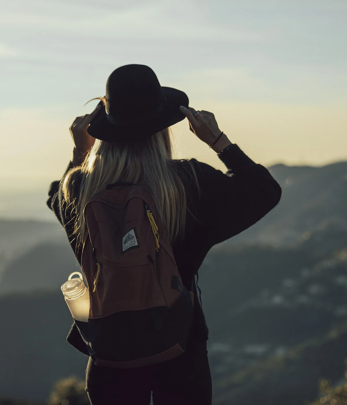 Solo traveller with a backpack overlooking the mountains