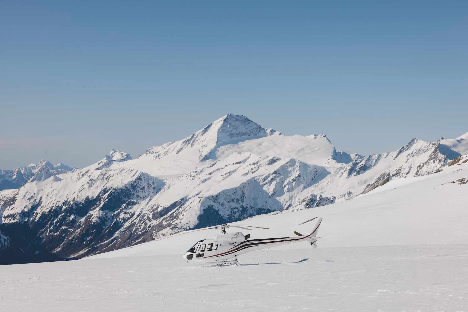 Helicopter above alpine snowfields near Mount Cook country